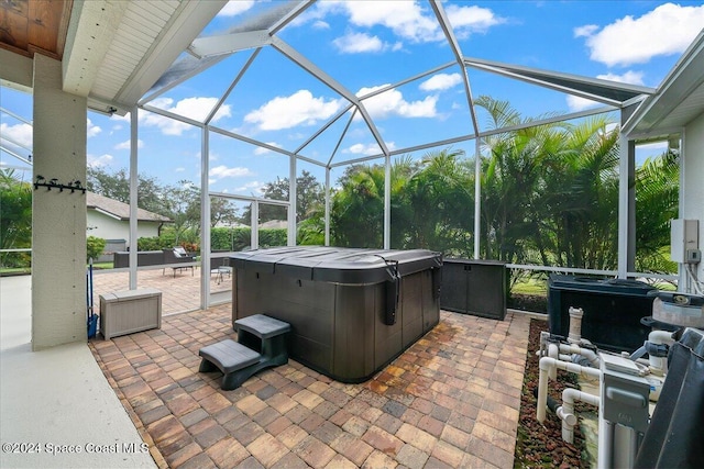 view of patio with a hot tub and glass enclosure