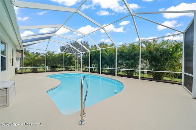 view of swimming pool with glass enclosure and a patio