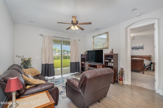 living room with light hardwood / wood-style floors and ceiling fan