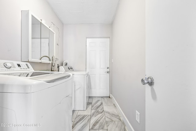 3524 S Atlantic Ave, Cocoa Beach, FL 32931 - clothes washing area with light marble finish floors, washing machine and dryer, and baseboards