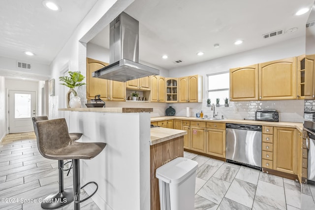 3524 S Atlantic Ave, Cocoa Beach, FL 32931 - kitchen with stainless steel dishwasher, island range hood, a kitchen breakfast bar, a sink, and tasteful backsplash