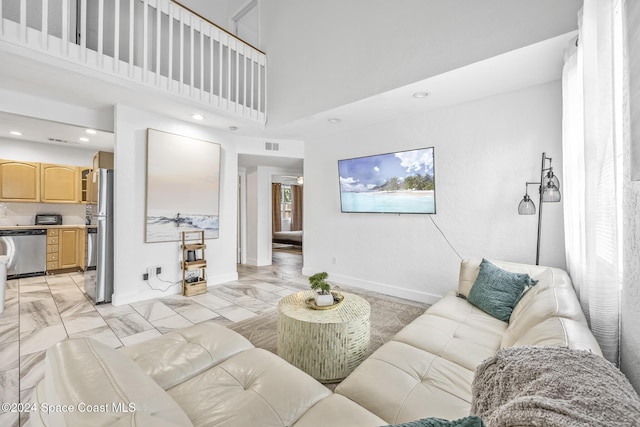 3524 S Atlantic Ave, Cocoa Beach, FL 32931 - living room with recessed lighting, light marble finish floors, a towering ceiling, and baseboards