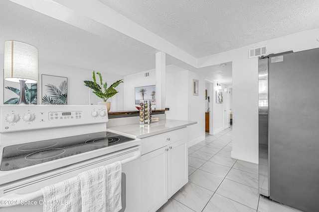 3524 S Atlantic Ave, Cocoa Beach, FL 32931 - kitchen with white range with electric stovetop, freestanding refrigerator, light marble finish floors, a textured ceiling, and white cabinets