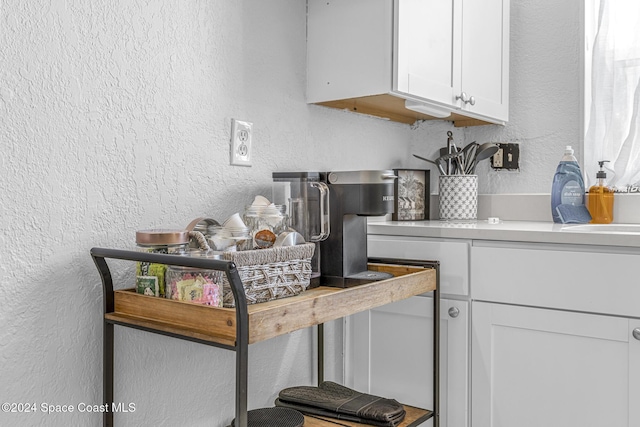 3524 S Atlantic Ave, Cocoa Beach, FL 32931 - kitchen featuring a textured wall, white cabinets, and light countertops