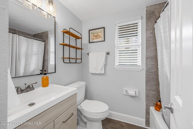 3524 S Atlantic Ave, Cocoa Beach, FL 32931 - full bathroom with a textured ceiling, toilet, baseboards, vanity, and wood finished floors