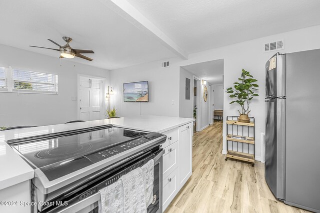 3524 S Atlantic Ave, Cocoa Beach, FL 32931 - kitchen featuring stainless steel appliances, white cabinets, a ceiling fan, light wood finished floors, and light countertops