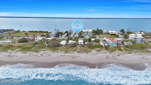 birds eye view of property featuring a water view and a beach view