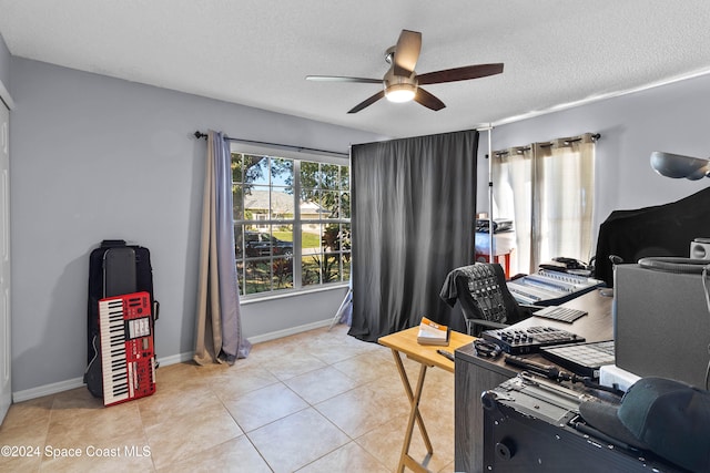 home office featuring ceiling fan, light tile patterned flooring, and a textured ceiling