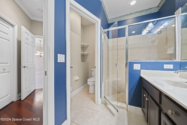 bathroom with vanity, toilet, an enclosed shower, and ornamental molding