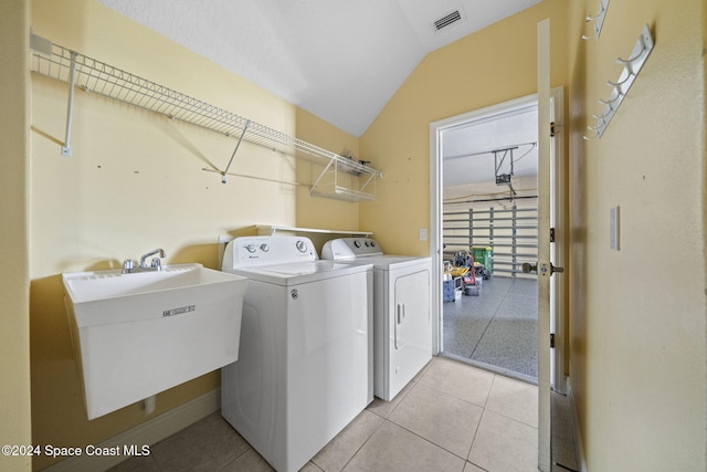 washroom with sink, light tile patterned floors, and independent washer and dryer