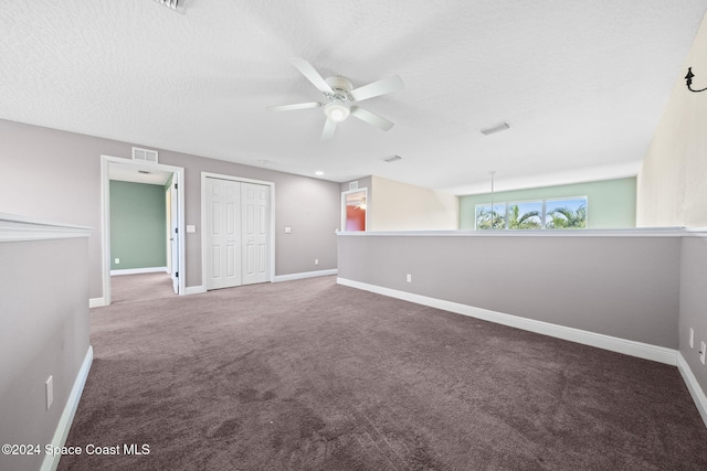 carpeted spare room featuring ceiling fan and a textured ceiling