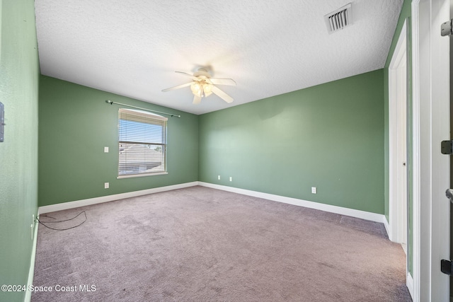 carpeted empty room featuring ceiling fan and a textured ceiling