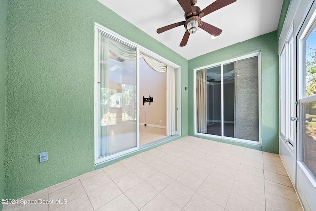 unfurnished sunroom with ceiling fan