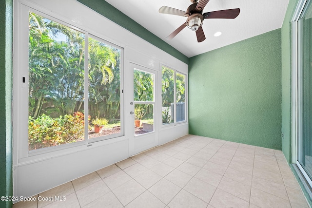 unfurnished sunroom featuring ceiling fan