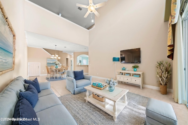 tiled living room featuring high vaulted ceiling and ceiling fan with notable chandelier