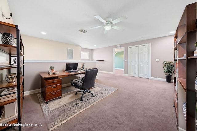 carpeted office space with ceiling fan