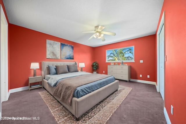 carpeted bedroom featuring ceiling fan and a closet