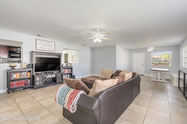 living room featuring a textured ceiling, light tile patterned flooring, and ceiling fan