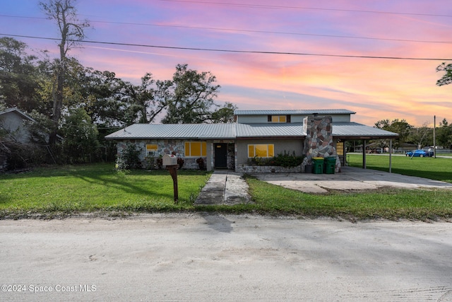 view of front of house featuring a lawn and a carport