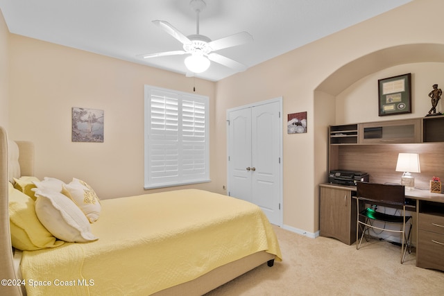 carpeted bedroom featuring a closet and ceiling fan