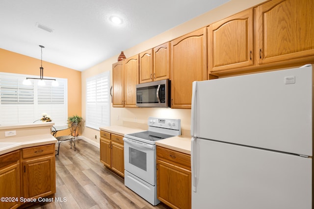 kitchen featuring light hardwood / wood-style flooring, hanging light fixtures, white appliances, and vaulted ceiling