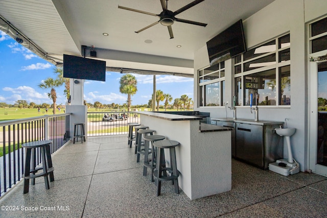 view of patio / terrace featuring ceiling fan and exterior bar