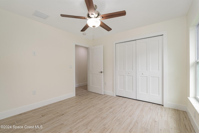 unfurnished bedroom with a closet, light hardwood / wood-style floors, and ceiling fan