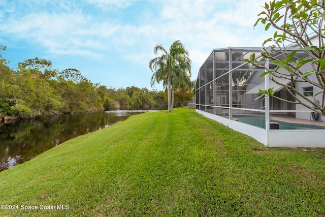 view of yard featuring a water view, a lanai, and an outdoor pool