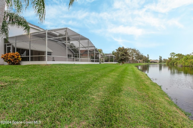 view of yard featuring a water view and glass enclosure