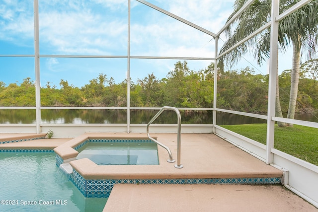 view of swimming pool featuring a pool with connected hot tub, a patio area, glass enclosure, and a water view