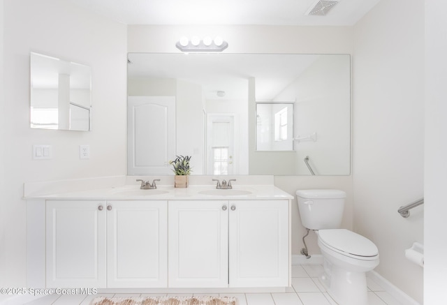 full bathroom with toilet, double vanity, a sink, and visible vents