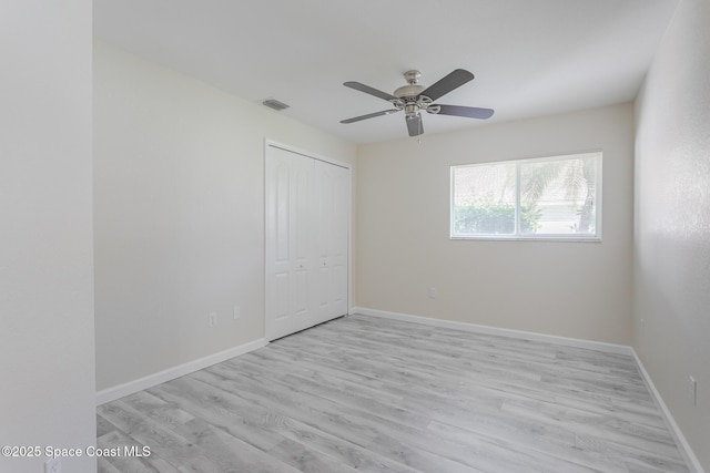 unfurnished bedroom with light wood finished floors, a closet, visible vents, and baseboards