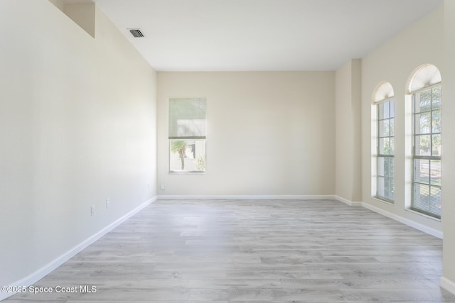 empty room with a healthy amount of sunlight, light wood-style flooring, and visible vents