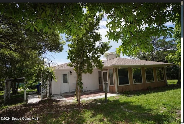 back of property featuring a patio area and a yard