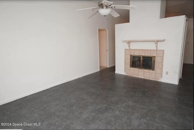 unfurnished living room with a tile fireplace, a high ceiling, and ceiling fan