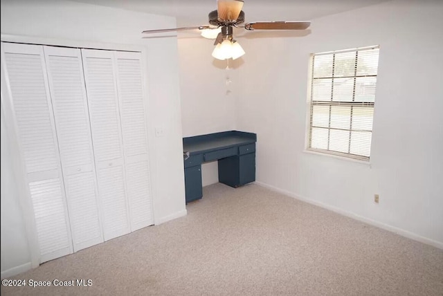 unfurnished bedroom featuring carpet, ceiling fan, and a closet