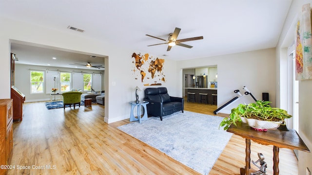 living room with ceiling fan and light hardwood / wood-style floors