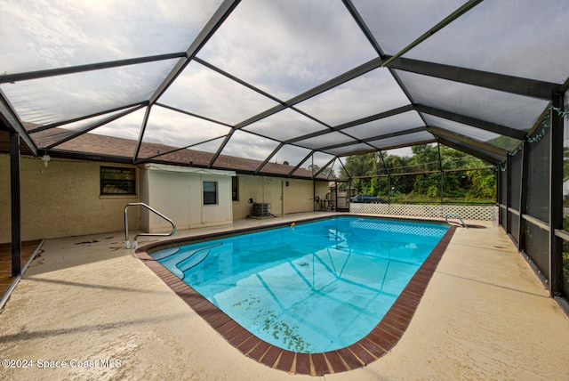 view of swimming pool with glass enclosure and a patio area