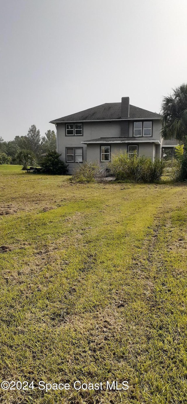 rear view of property with a yard