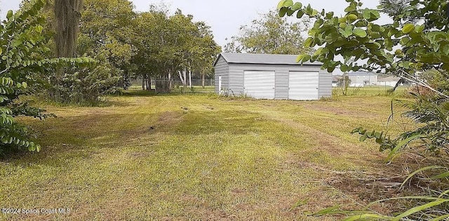 view of yard with a storage shed, an outdoor structure, and fence