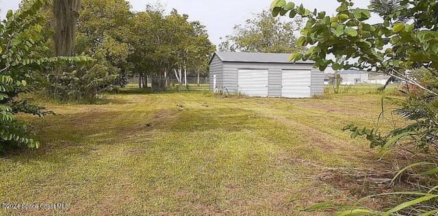 2790 Celery Ave, Sanford, FL 32771 - view of yard with a detached garage, fence, an outdoor structure, and a storage unit
