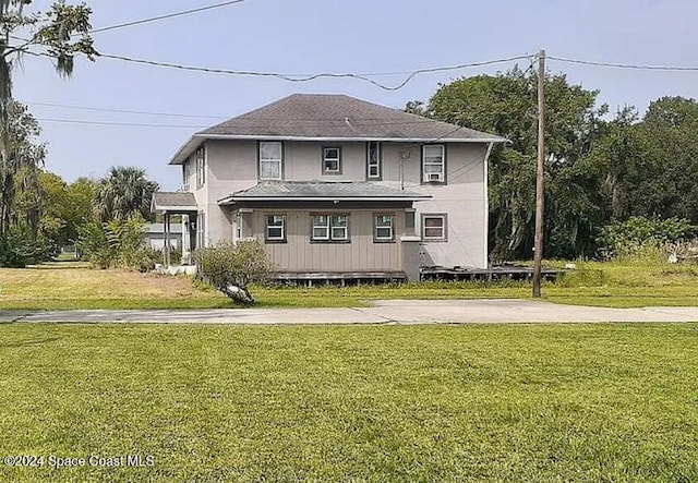 view of front of house with roof with shingles and a front lawn