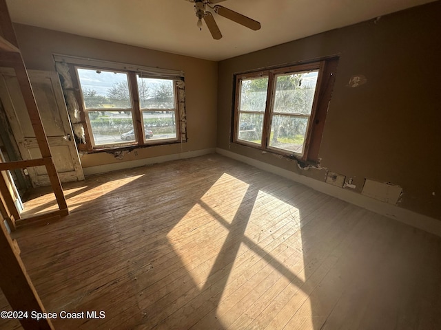 unfurnished room with hardwood / wood-style floors, baseboards, and ceiling fan