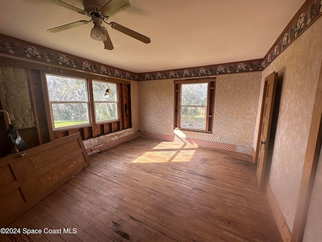 unfurnished room featuring wallpapered walls, baseboards, and hardwood / wood-style floors