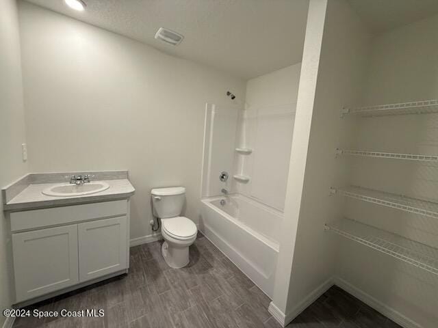 full bathroom with bathing tub / shower combination, hardwood / wood-style flooring, vanity, and toilet