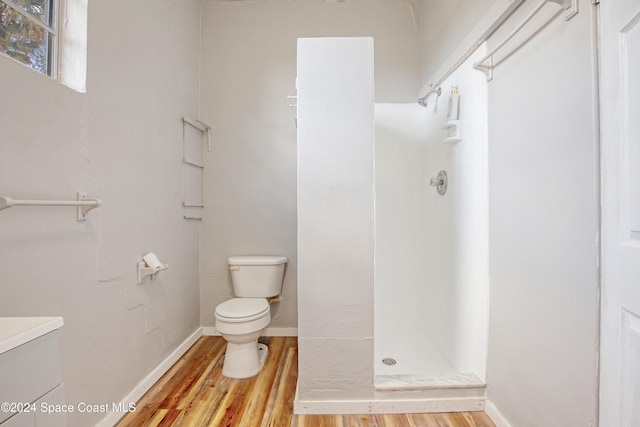 bathroom featuring a shower, toilet, and hardwood / wood-style flooring