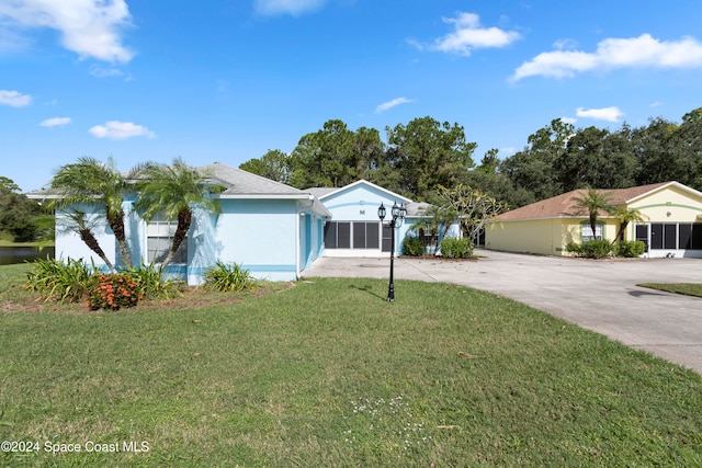 single story home featuring a front lawn and a garage