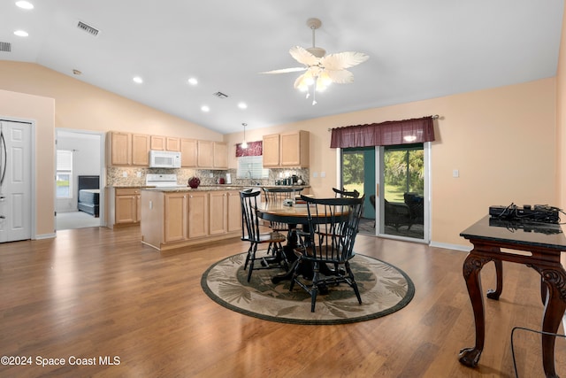 dining room with light hardwood / wood-style floors, ceiling fan, and vaulted ceiling