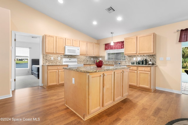 kitchen featuring stove, light brown cabinets, and decorative light fixtures