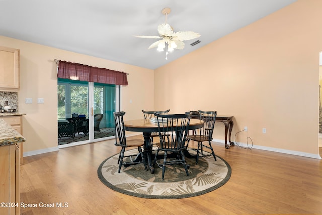 dining room featuring light hardwood / wood-style floors, vaulted ceiling, and ceiling fan